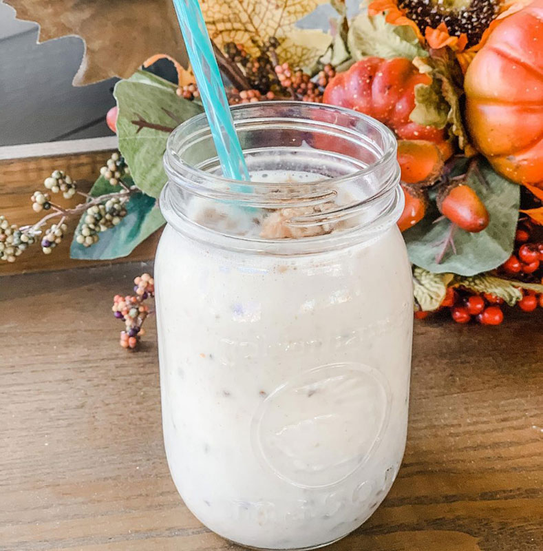 An autumn smoothie in a mason jar served with a straw.