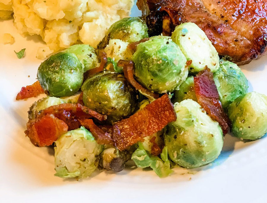 Seasoned Brussels sprouts with bacon served on a plate.