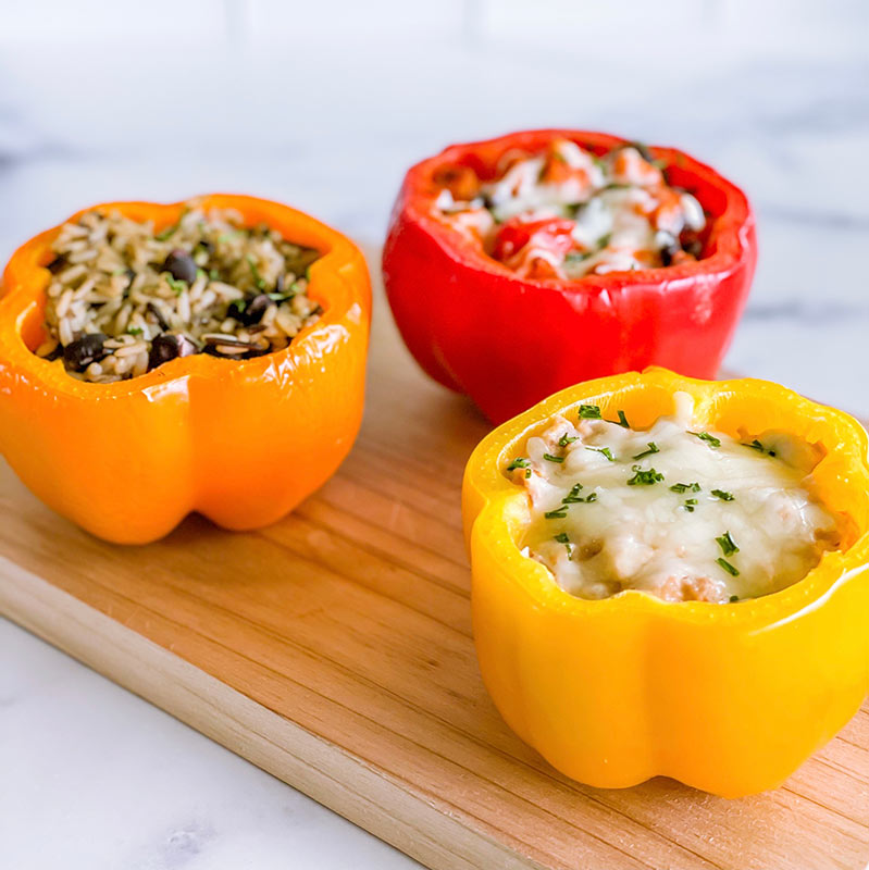 Three prepared stuffed bell peppers.