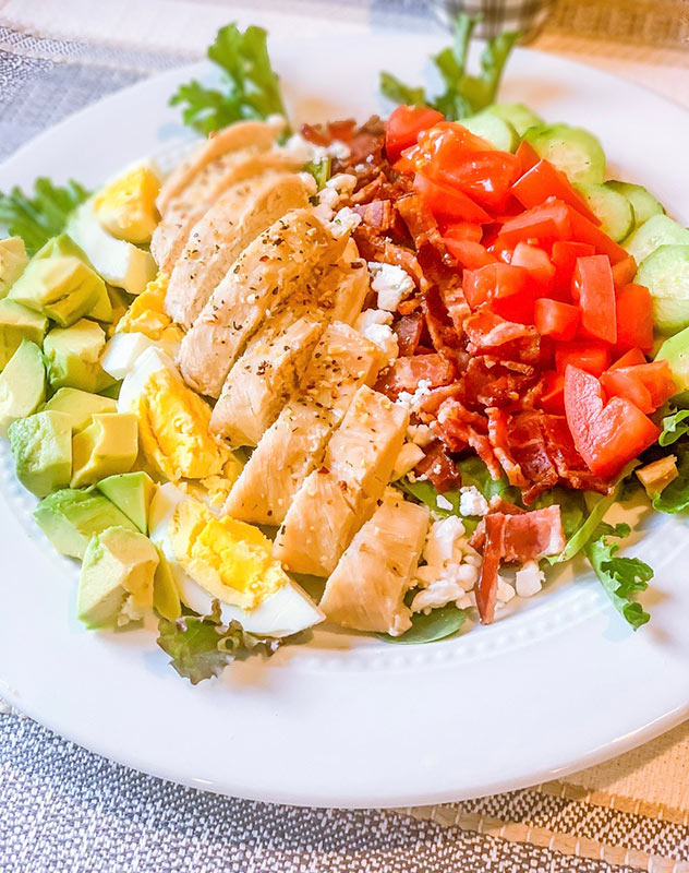 A colorful cobb salad on a plate.