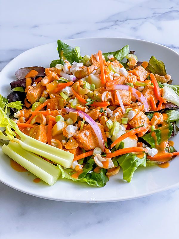 Buffalo Chicken Salad on a plate with dressing.
