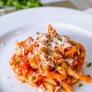 A scoop of penne pasta with homemade tomato sauce.
