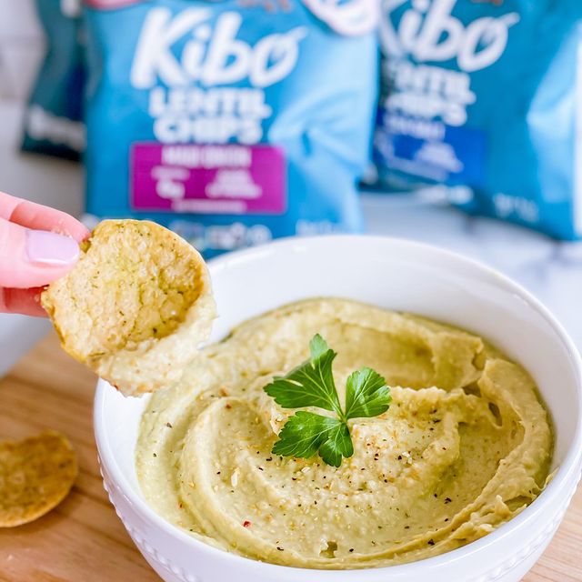 A bowl of avocado hummus served with chips